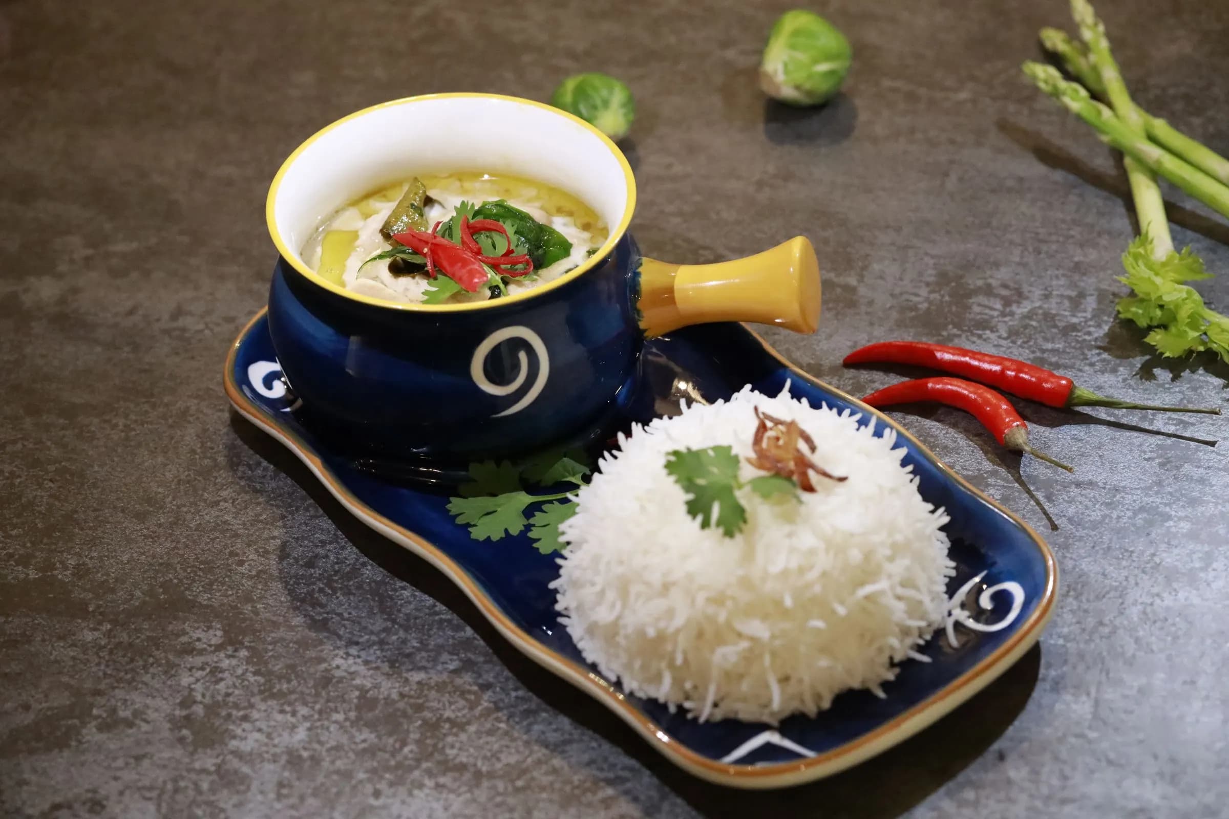 Green curry and rice on a ceramic tray