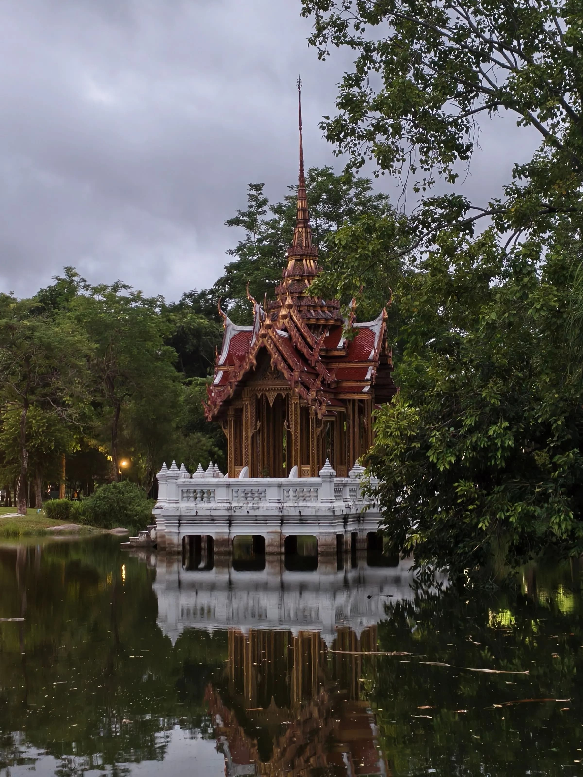 Thai pavilion reflected in a lake at dusk