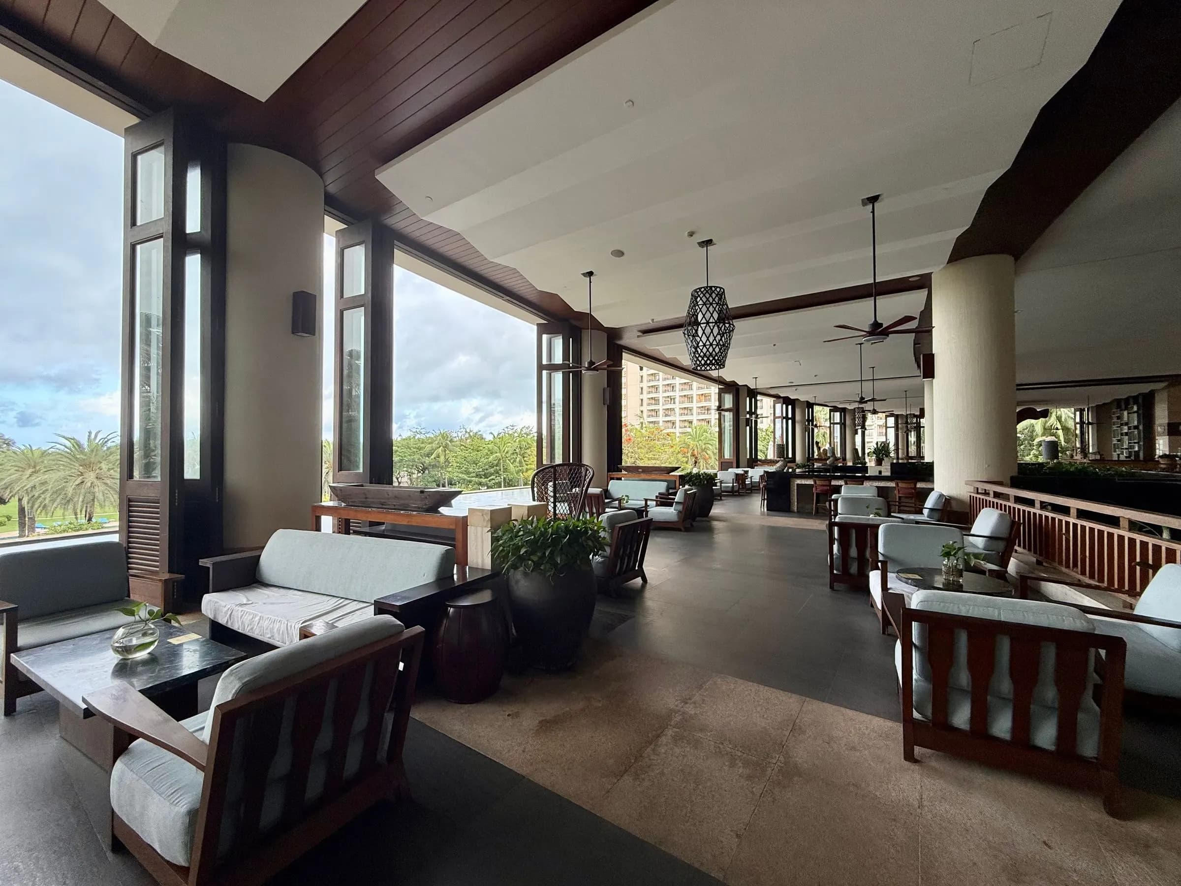 Resort lounge with large windows and palm trees