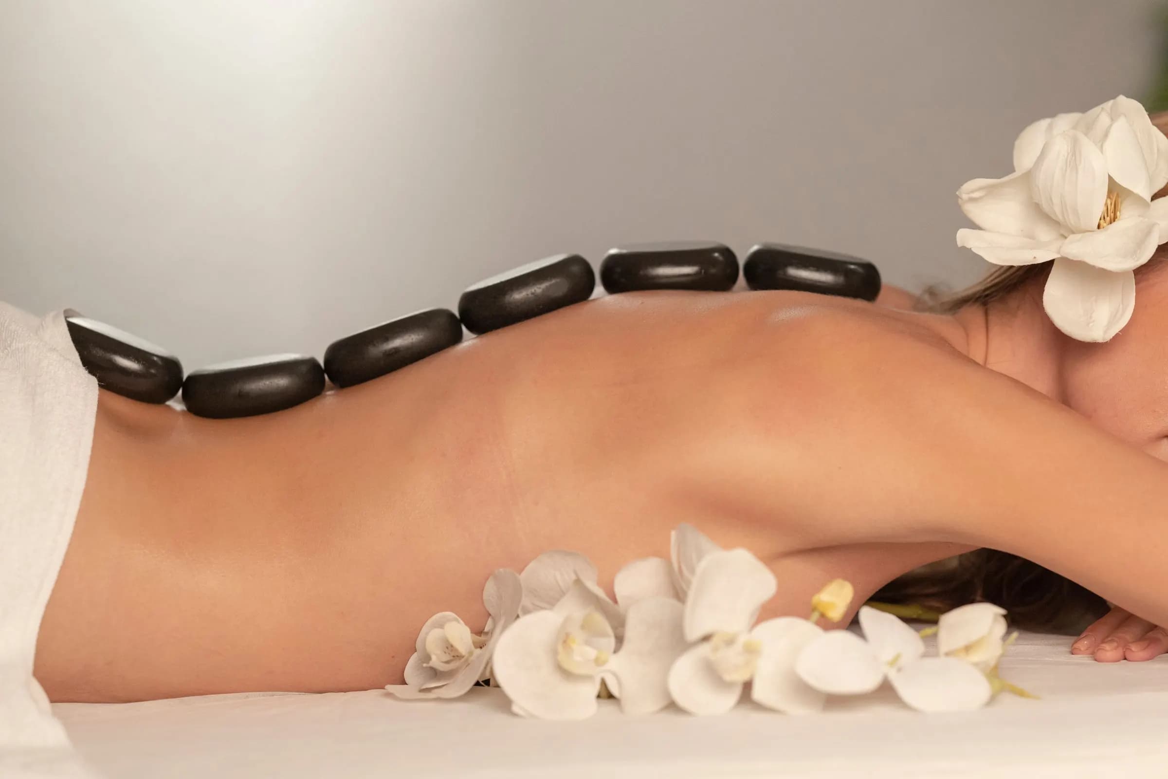 Hot stone therapy with white flowers