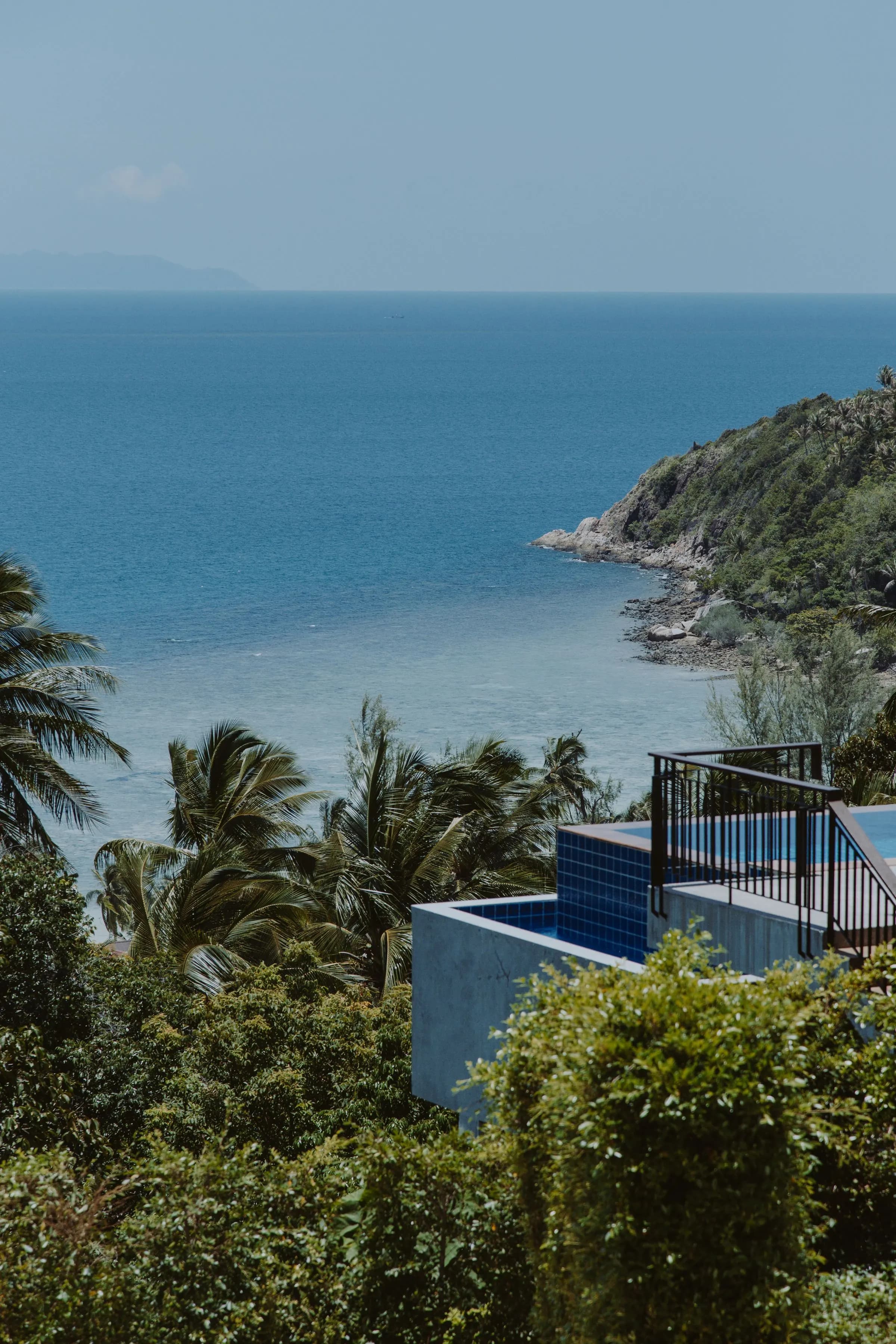 Pool terrace overlooking the sea and tropical greenery