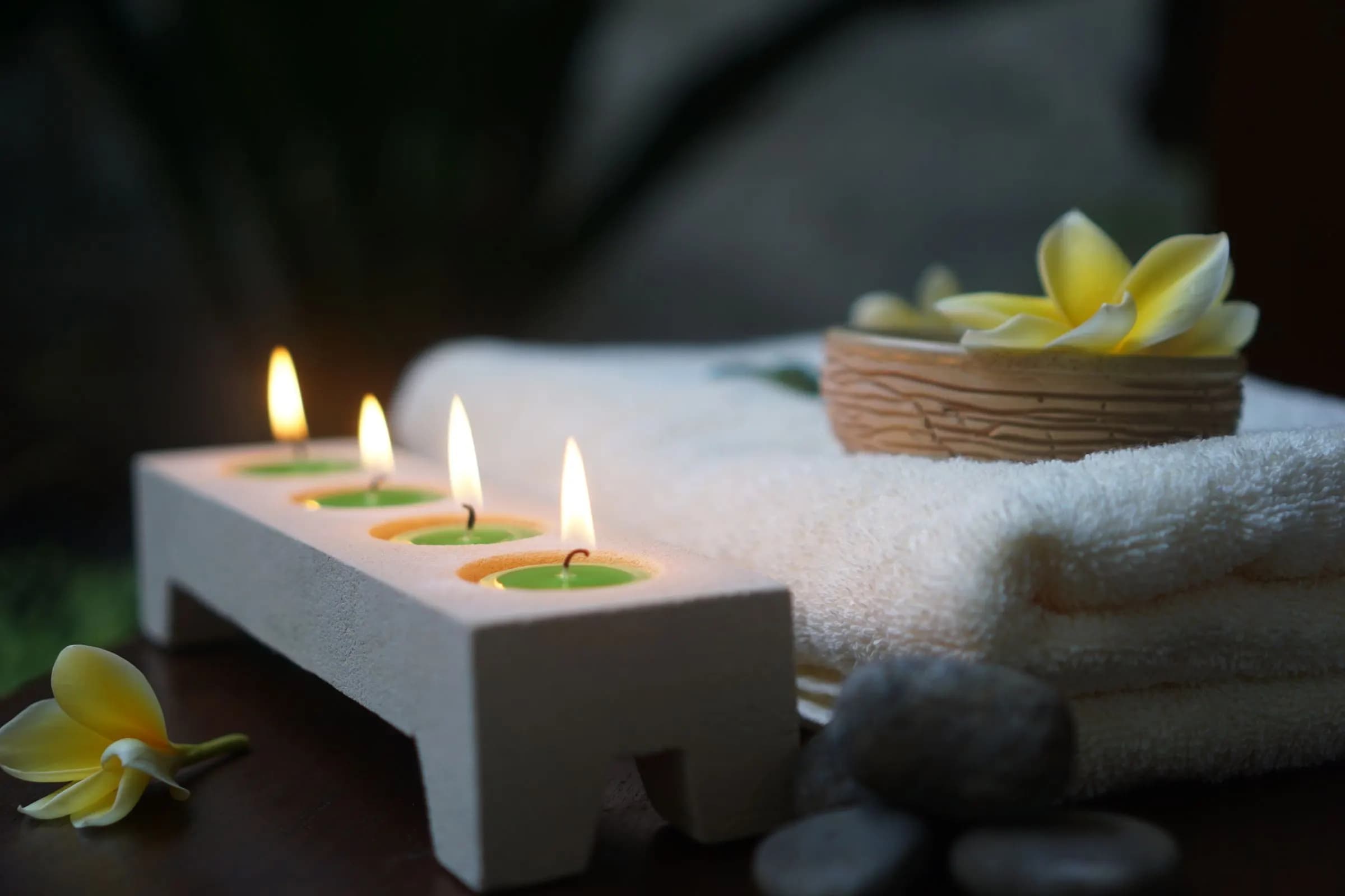 Candles, towels and frangipani in a spa