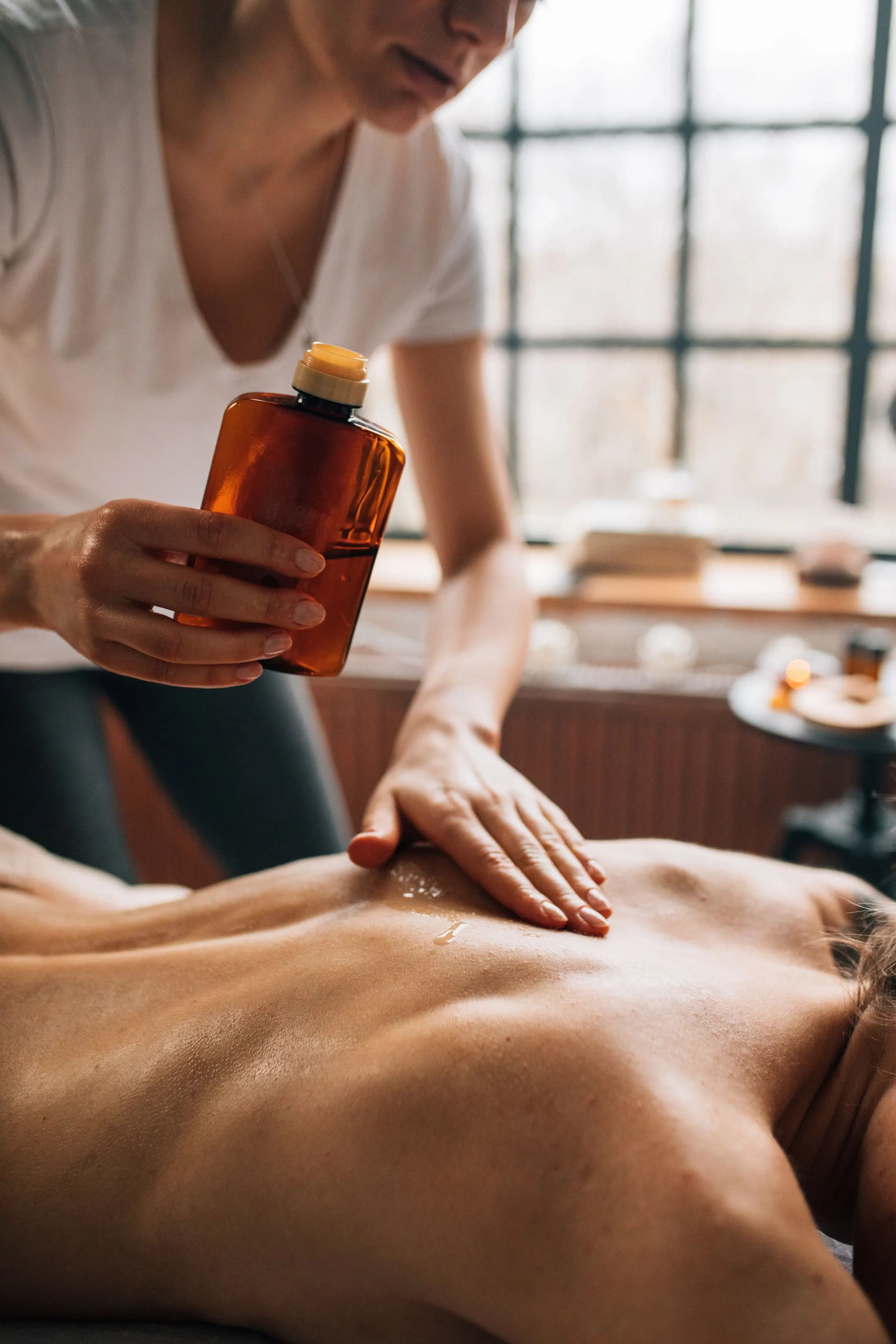 Therapist holding massage oil